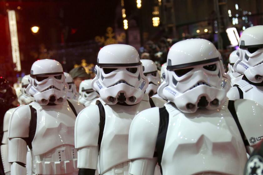 FILE - In this Dec. 16, 2015. file photo, people dressed as stormtroopers walk on the red carpet upon arrival at the European premiere of the film 'Star Wars: The Force Awakens' in London. Multiple stories on sites resembling local affiliate TV stations have published false casting calls claiming the a Star Wars movie is going to be filmed towns across the United States, interchanging the name of the town and promoting a new movie about a previously unknown planet in the Star Wars universe. The only Star Wars movie in production in May 2017 is the untitled Han Solo Film, which began shooting in January outside London. (Photo by Joel Ryan/Invision/AP, File)