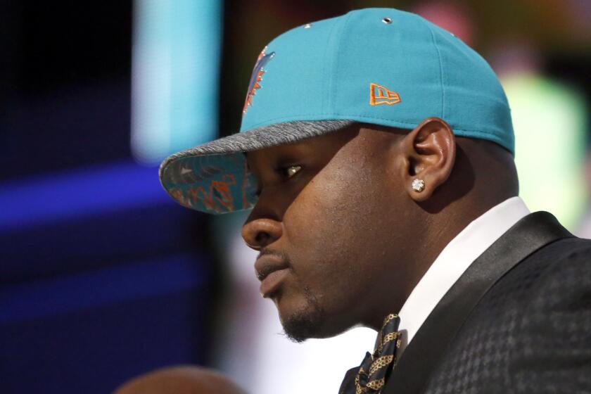 Laremy Tunsil poses for photos after being selected by the Miami Dolphins with the 13th pick in the first round of the NFL draft on Thursday in Chicago.