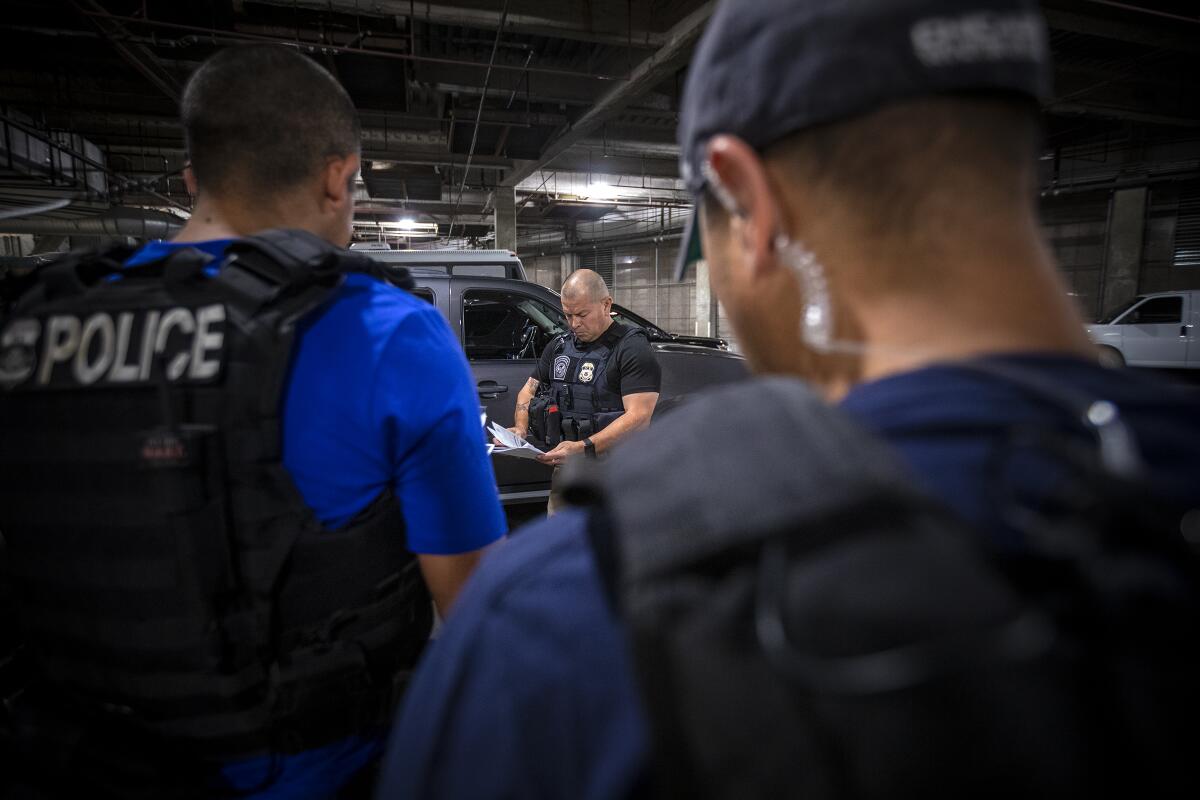 David Marin, director de operaciones de control y deportación, discute los planes de incursión con su equipo antes de salir a detener a fugitivos que tienen órdenes finales de deportación. (Irfan Khan / Los Angeles Times)