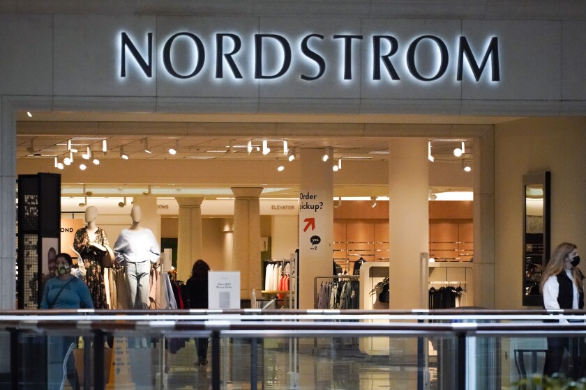 Shoppers walk near an entrance to a Nordstrom store at a shopping mall in Pittsburgh on Wednesday, Feb. 24, 2021. Nordstrom says it's acquiring a minority interest in four fashion brands owned by a British company called Asos as the department store aims to reach out to younger customers. The brand - Topshop, Topman, Miss Selfridge and HIIT - were purchased by Asos in February after their previous owner and British fashion empire Arcadia Group filed for bankruptcy in late 2020. (AP Photo/Keith Srakocic)