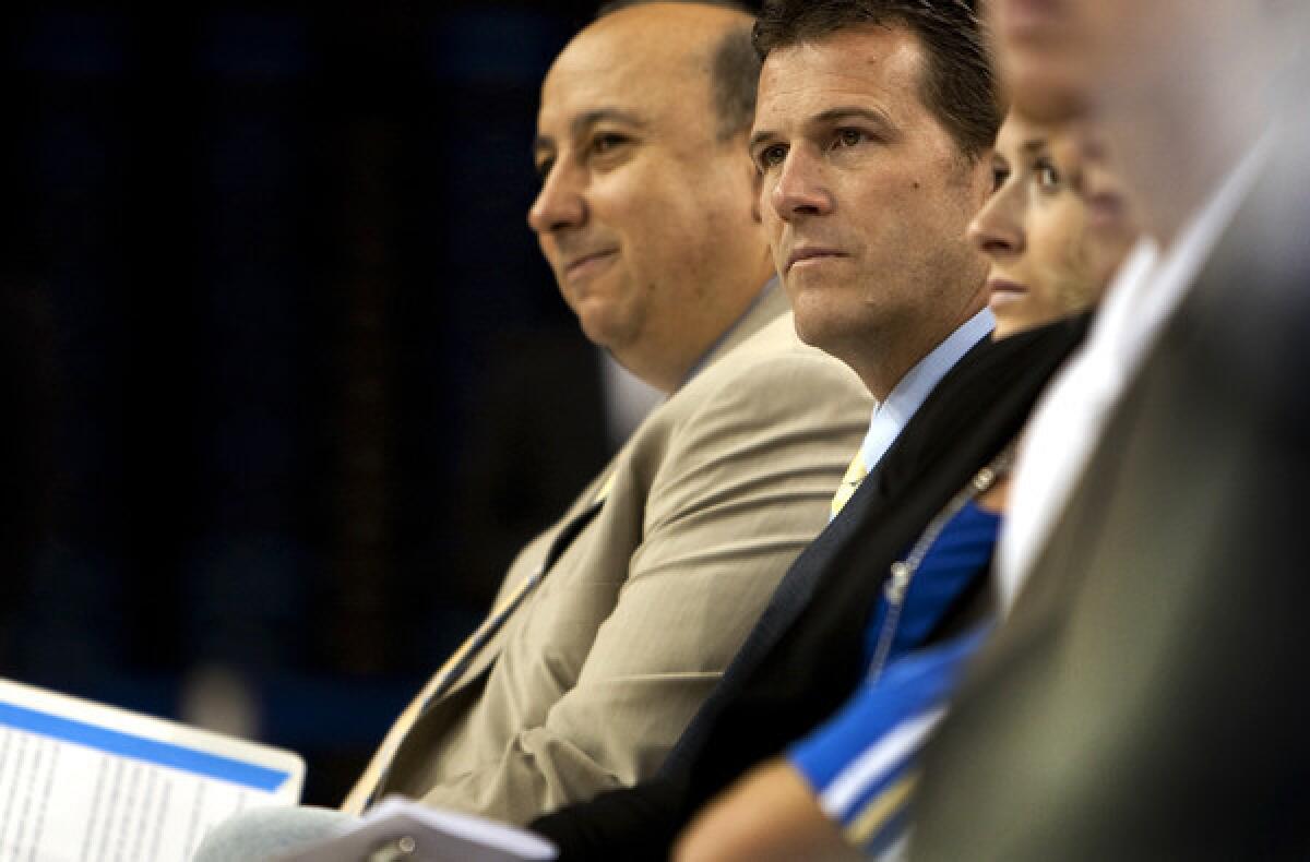 UCLA Athletic Director Dan Guerrero, left, and Steve Alford listen to a speaker during the introduction of Alford as the Bruins' new men's basketball coach.