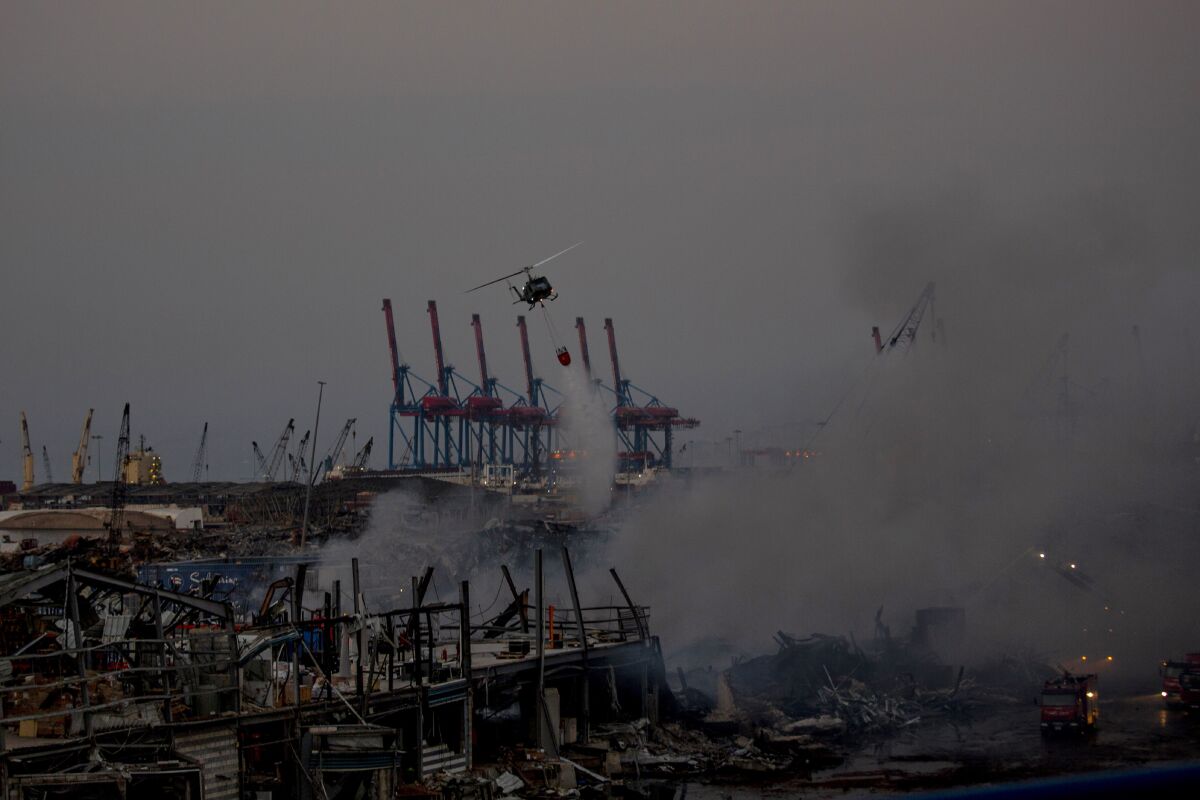 An army helicopter drops water on a fire at warehouses at the seaport in Beirut, Lebanon, Friday, Sept. 11, 2020. A huge fire has broken out Yesterday at the Port of Beirut, sending up a thick column of black smoke and raising new panic among traumatized residents after last month's catastrophic blast at the same site. (AP Photo/Hassan Ammar)