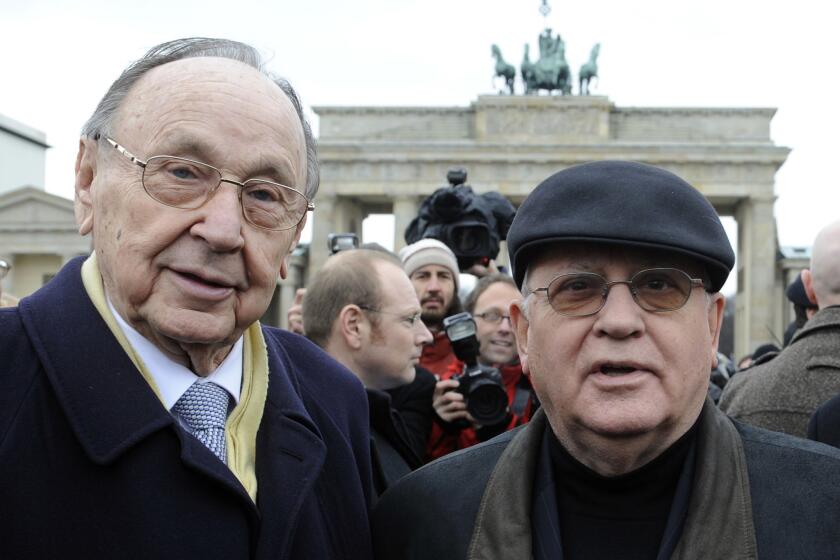 Former West German Foreign Minister Hans-Dietrich Genscher, left, with former Soviet leader Mikhail S. Gorbachev at the Brandenburg Gate in Berlin in 2009, two decades after the fall of the Berlin Wall.