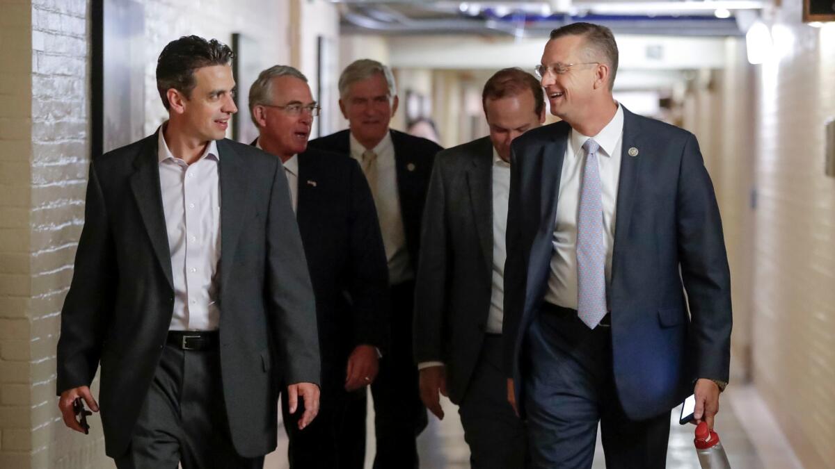 Rep. Justin Amash (R-Mich.), far left, and Rep. Doug Collins (R-Ga.), far right, head to a meeting July 14 with fellow Republicans to reconcile the GOP's long-overdue budget blueprint.