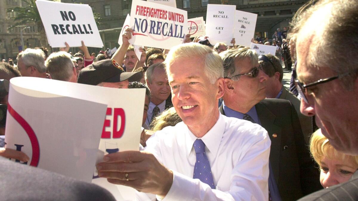 Then-California Gov. Gray Davis autographs picket signs during a campaign stop in San Francisco in October 2003, just before voters recalled him from office.