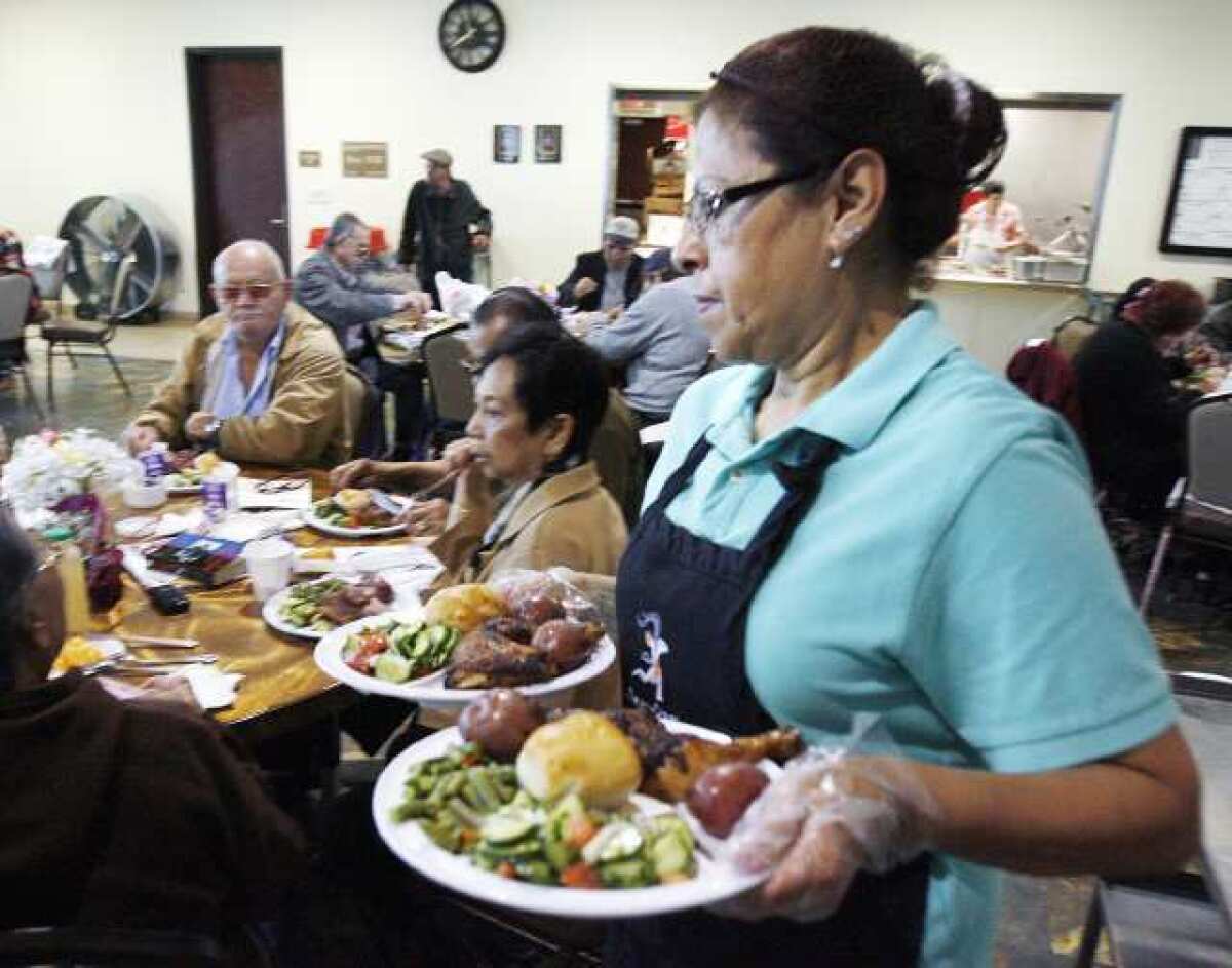 Food server Susanna Leos serves dinners to guests who have a ticket at the Adult Recreation Center in Glendale.