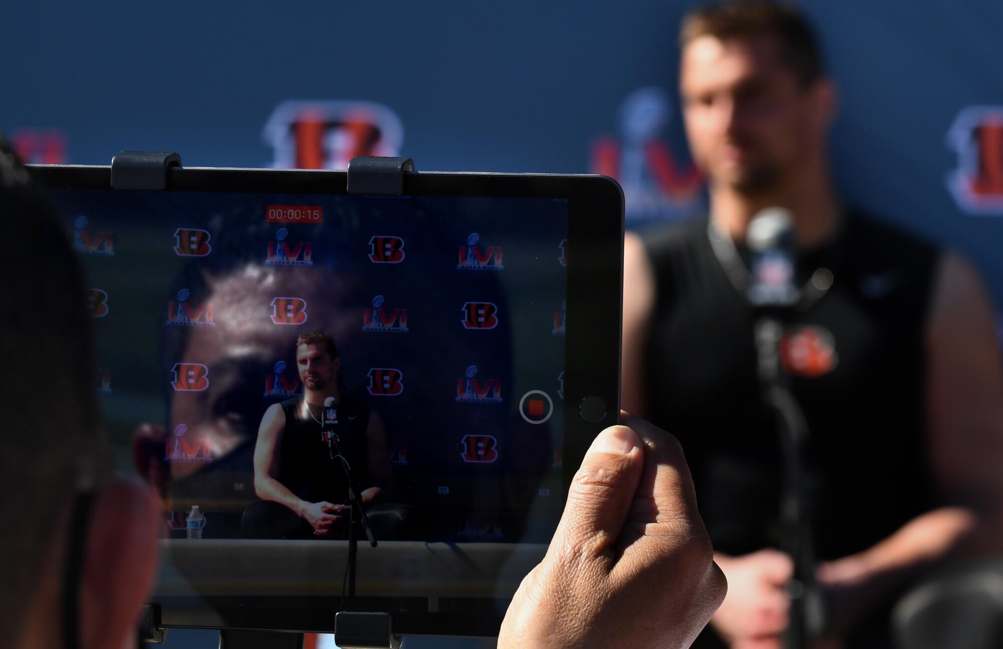 A reporter records an interview during media day at the Bengals camp before the Super Bowl at UCLA on Friday.