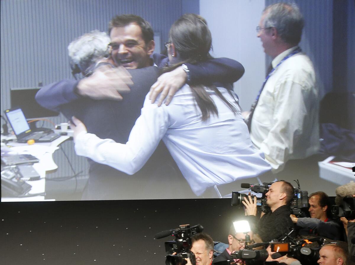 Celebrating scientists in the main control room appear on a video screen at the European Space Agency after the first unmanned spacecraft Philae landed on a comet.