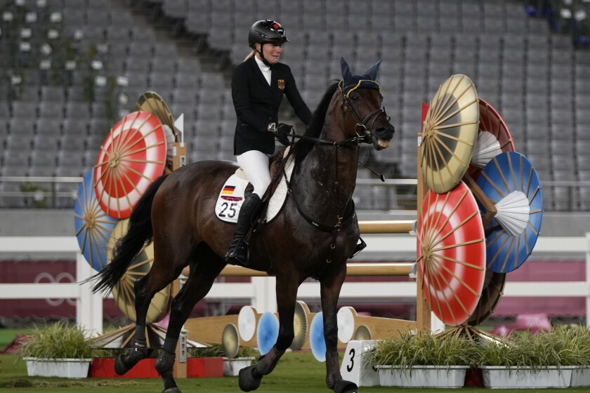Annika Schleu of Germany cries as she couldn't controls her horse to compete in the equestrian portion of the women's modern pentathlon at the 2020 Summer Olympics, Friday, Aug. 6, 2021, in Tokyo, Japan. (AP Photo/Hassan Ammar)