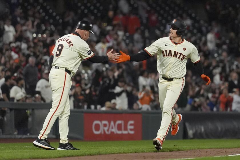 Matt Chapman, de los Gigantes de San Francisco (derecha), recibe la felicitación del entrenador de tercera base Matt Williams (9) tras sacudir un jonrón en el sexto inning del juego de la MLB que enfrentó a su equipo con los Medias Blancas de Chicago, en San Francisco, el 19 de agosto de 2024. (AP Foto/Jeff Chiu)