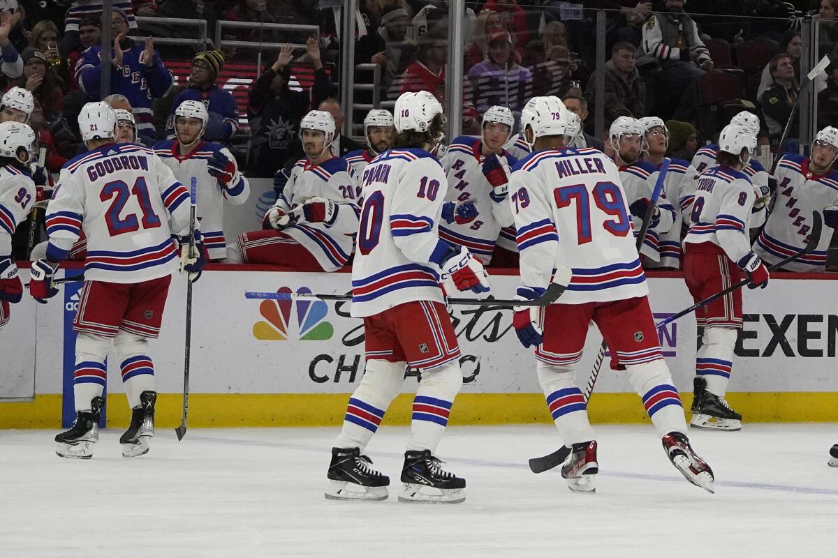 New York Rangers defenseman Jacob Trouba (8), back right, celebrates his goal against the Chicago Blackhawks during the second period of an NHL hockey game Sunday, Dec. 18, 2022, in Chicago. (AP Photo/David Banks)