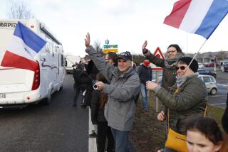 People wave to a convoy departing for Paris, Friday, Feb.11, 2022 in Strasbourg, eastern France. Authorities in France and Belgium have banned road blockades threatened by groups organizing online against COVID-19 restrictions. The events are in part inspired by protesters in Canada. Citing "risks of trouble to public order," the Paris police department banned protests aimed at "blocking the capital" from Friday through Monday. (AP Photo/Jean-Francois Badias)