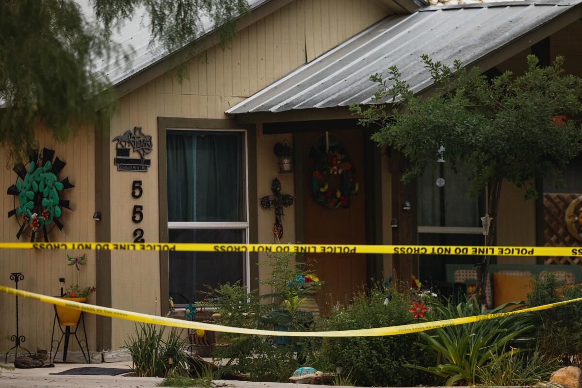 Yellow tape reading "Police line/Do not cross" in front of a home