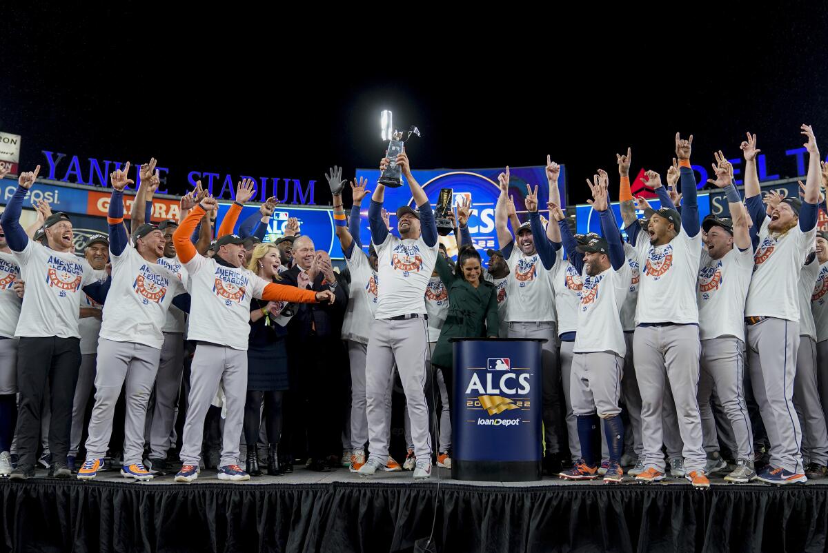 The Houston Astros celebrate with the American League Championship trophy after defeating the New York Yankees in the ALCS.
