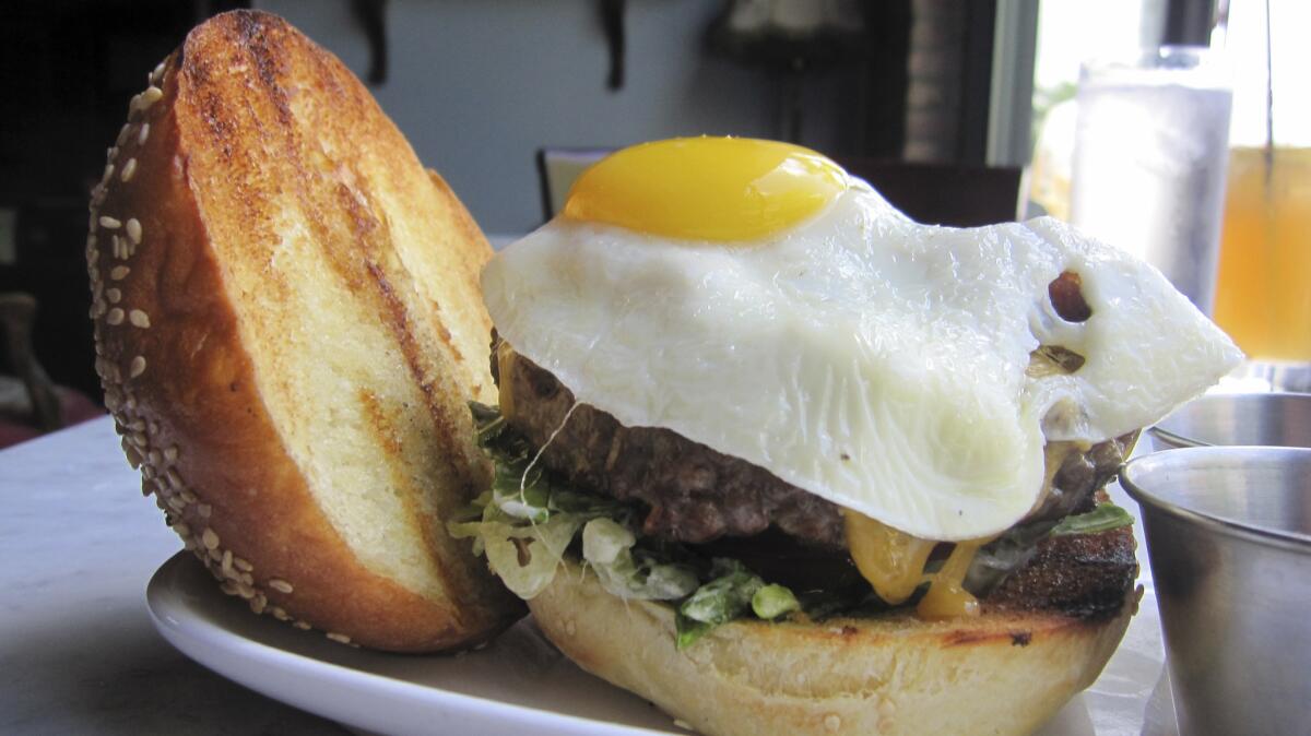 A burger at Old Town Social boasts house-made bacon and a fried egg.