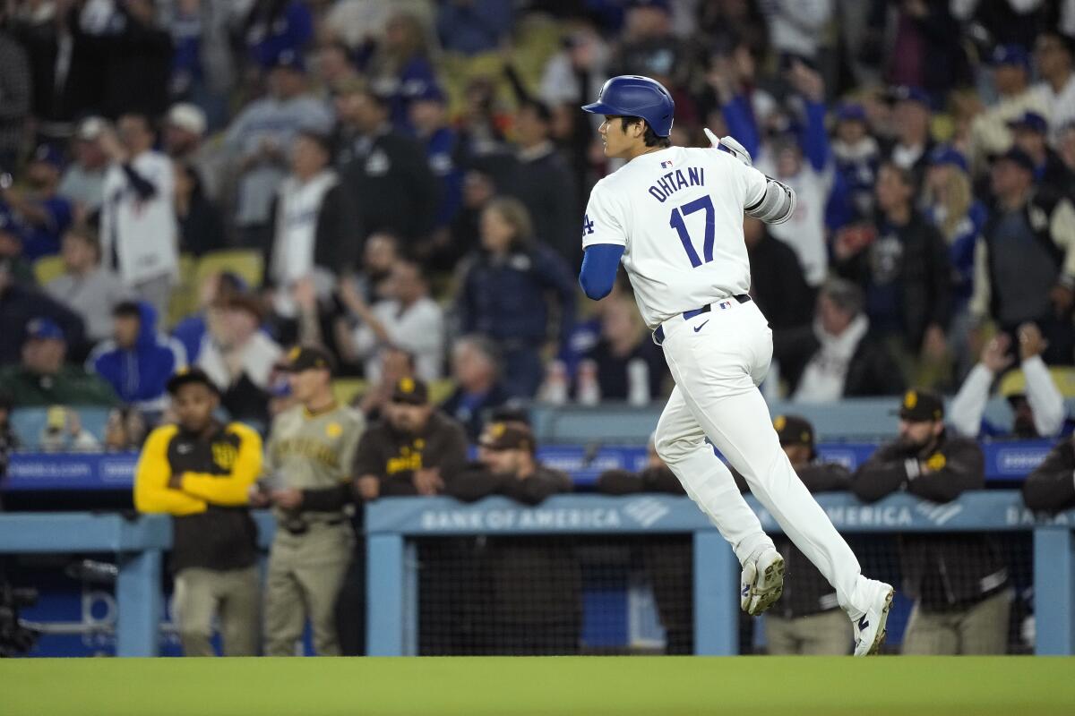 Los Angeles Dodgers' Shohei Ohtani gestures as he heads to first after hitting a solo home run.