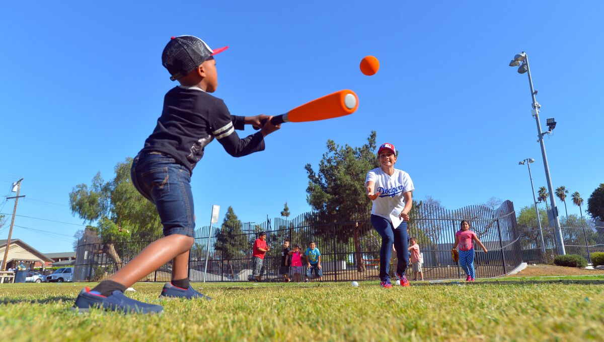 Rep. Nanette Barragán pitches to Braxton Jones, 4, during a baseball-themed town hall event April 21 at Wilson Park in Compton. Barragán held the event, "Catch with your congresswoman," during her weekend visit to her congressional district.