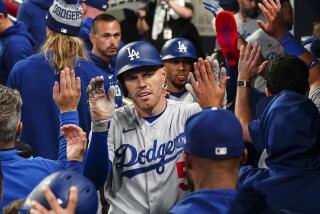 Los Angeles Dodgers' Freddie Freeman (5) celebrates in the dugout after hitting a three-run home run.
