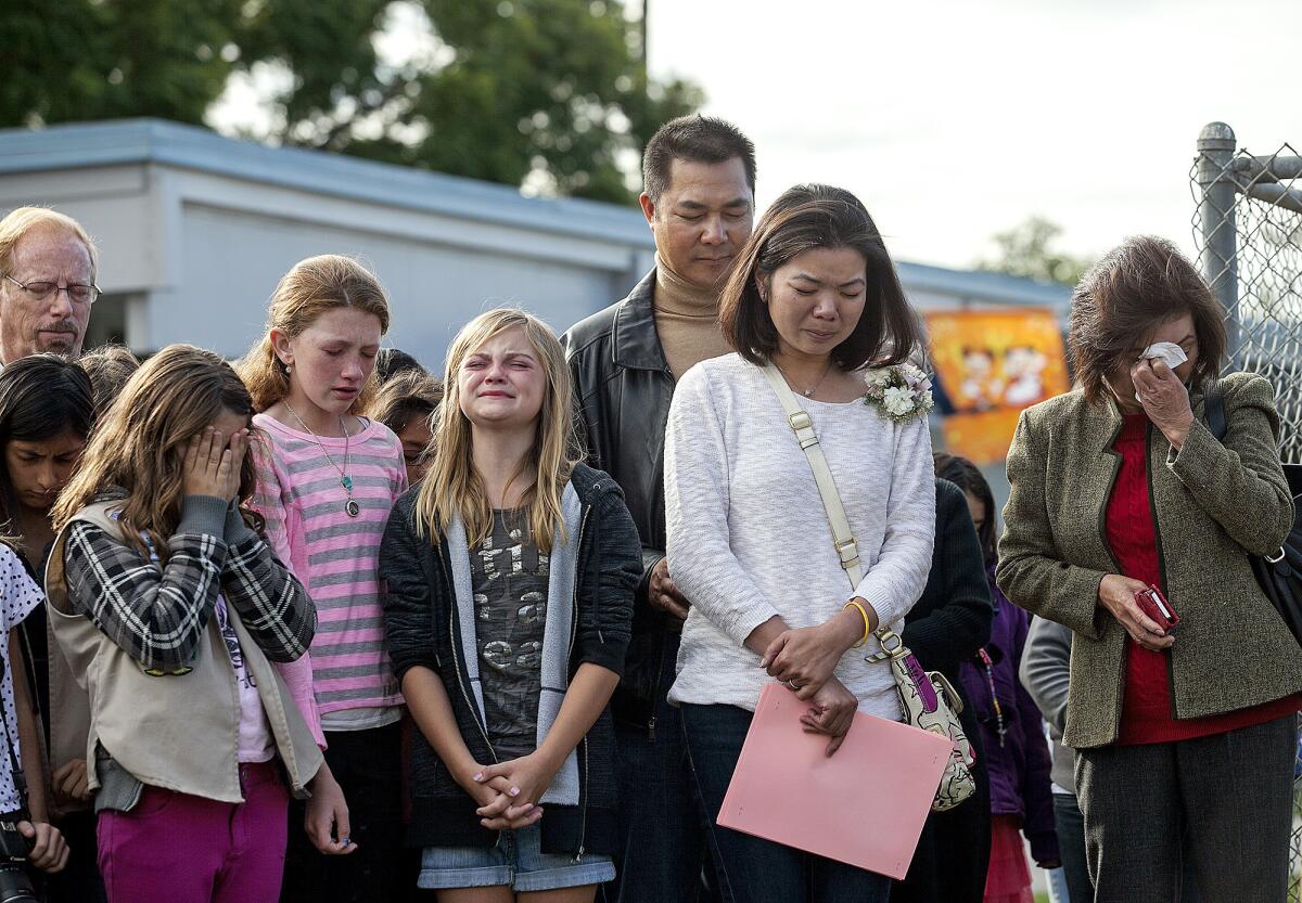 Vince and Karen Nguyen, center, and Dao Tran, the mother, father and grandmother of Samantha Nguyen, along with her friends Tristen Taber, left, Lexi Rae, and Alexa Tickenoff grieve during the dedication of a tree to honor Samantha at Sonora Elementary School on Friday, November 22. Samantha, who was a sixth grade student at the school, died in a boating accident earlier in the school year. The school also dedicated a bookshelf and bench in Samantha's name.