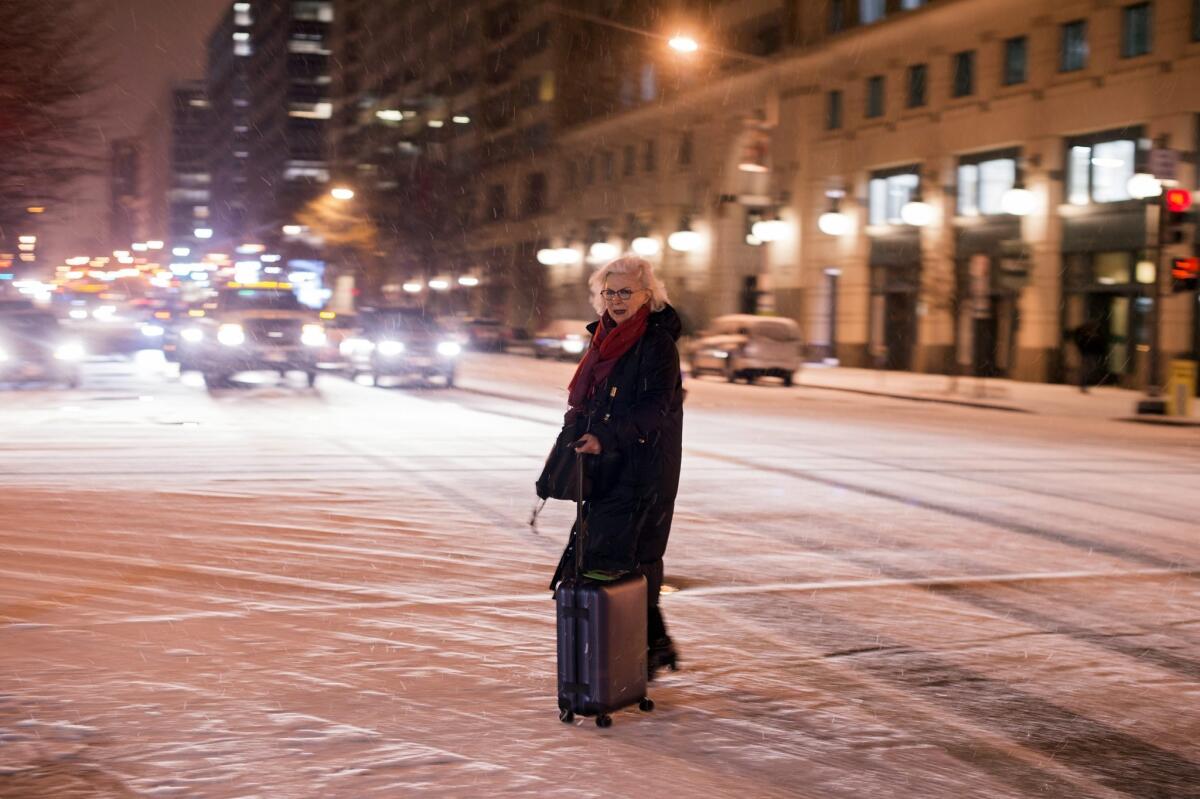 A woman crosses a snow-covered road in downtown Washington.