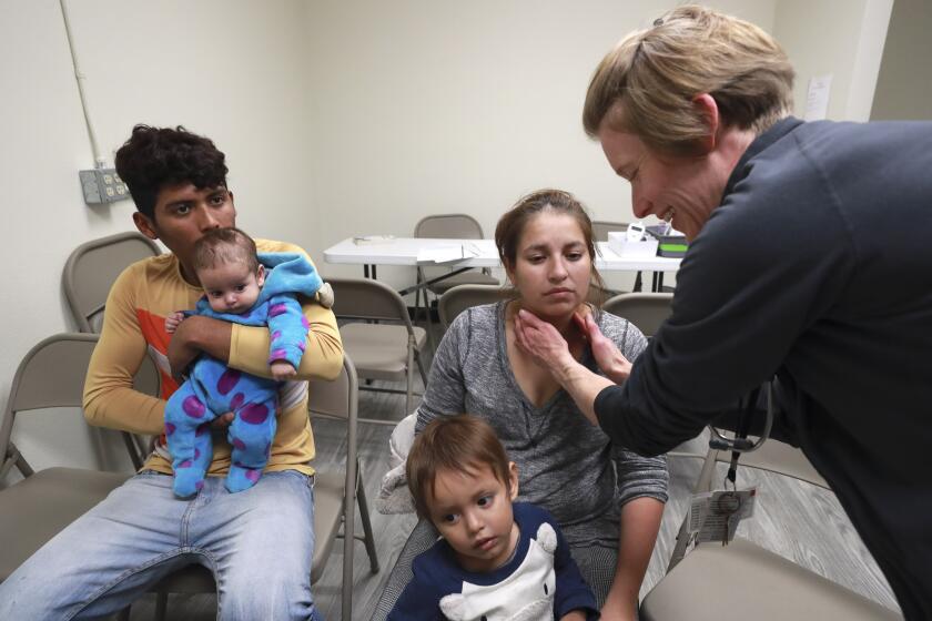 Dr. Gwen Gleason-Rohrer does a health screening on a young migrant family from Mexico as part of the intake process at the newly relocated JFS Migrant Family Shelter on Friday, January 10, 2020 in San Diego, California.