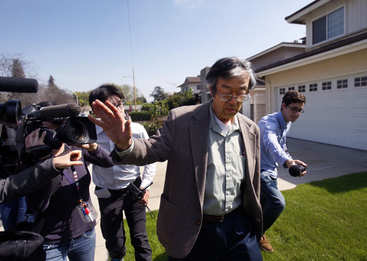 Journalists surround the man believed to be Bitcoin's creator, Dorian Satoshi Nakamoto, as he walks from his home to a car in Temple City.