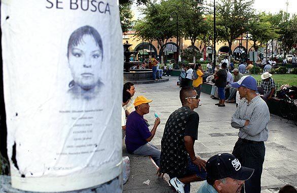 A poster seeking information about Elizabeth Saavedra Cordero,18, is taped to a post in a crowded plaza in downtown Ciudad Juarez. More than two dozen girls and young women have gone missing in the last 18 months in this violent border city, which has been rocked by drug-related violence.