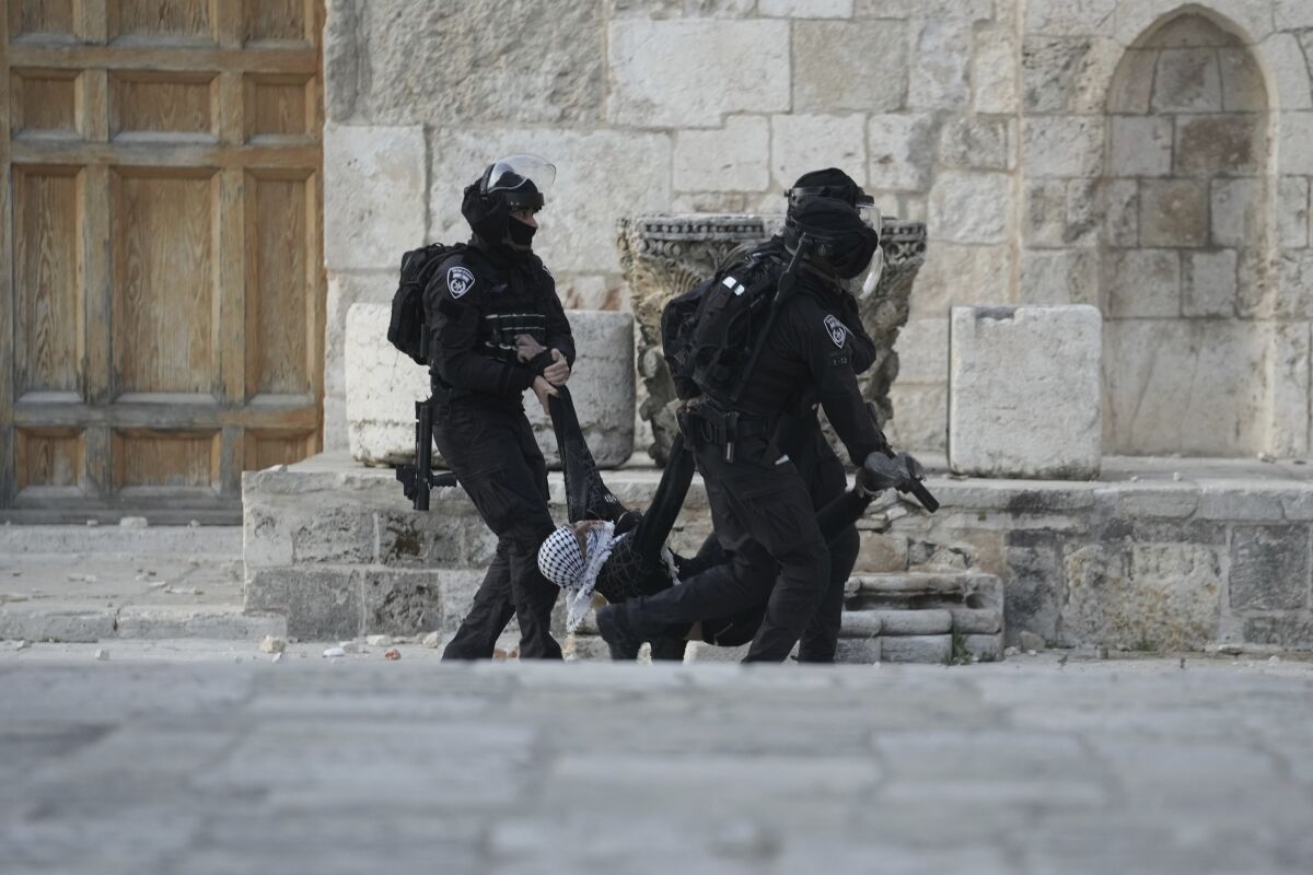 FILE - Israeli police carry a Palestinian protester during clashes at the Al Aqsa Mosque compound in Jerusalem's Old City, on April 22, 2022. The 21-year-old Palestinian man died Saturday, May 14, 2022, from a head wound sustained last month after Israeli police fired rubber bullets at stone-throwing Palestinian demonstrators during violence at Jerusalem’s most sensitive holy site. (AP Photo/Mahmoud Illean, File)