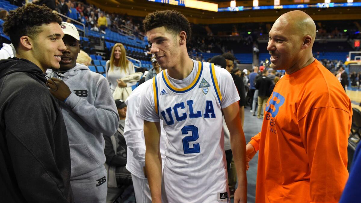 UCLA's Lonzo Ball (2) greets his brother LiAngelo Ball, left, and father LaVar Ball after a game against Long Beach State on Nov. 20.