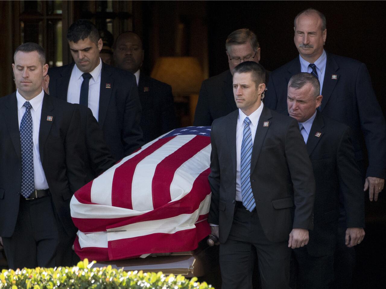Members of the Secret Service place the casket in a hearse at George H. Lewis Funeral Home after a Bush family service in Houston