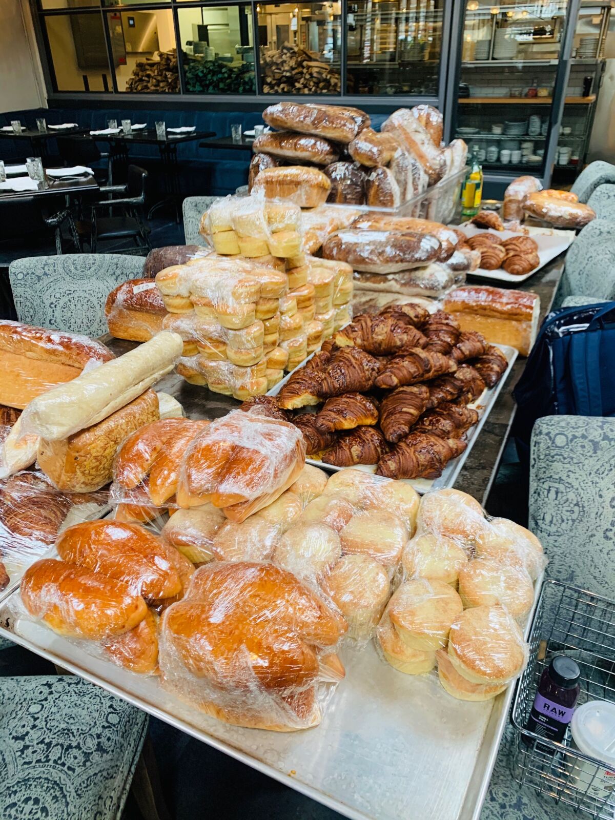 Stacks of fresh-baked pastries and breads that were distributed to employees on Sunday after Herb & Wood restaurant shut down in Little Italy due to the COVID-19 pandemic.