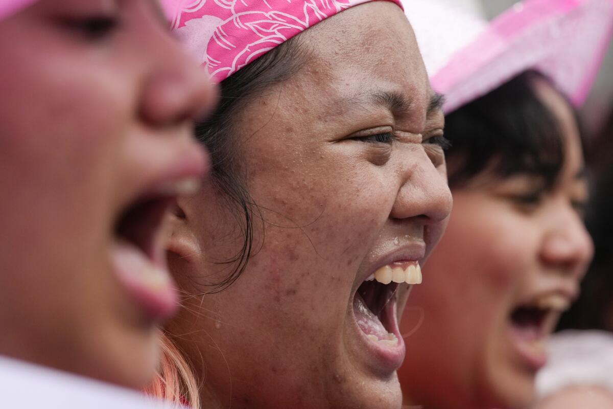 A close up of three women shouting slogans. 