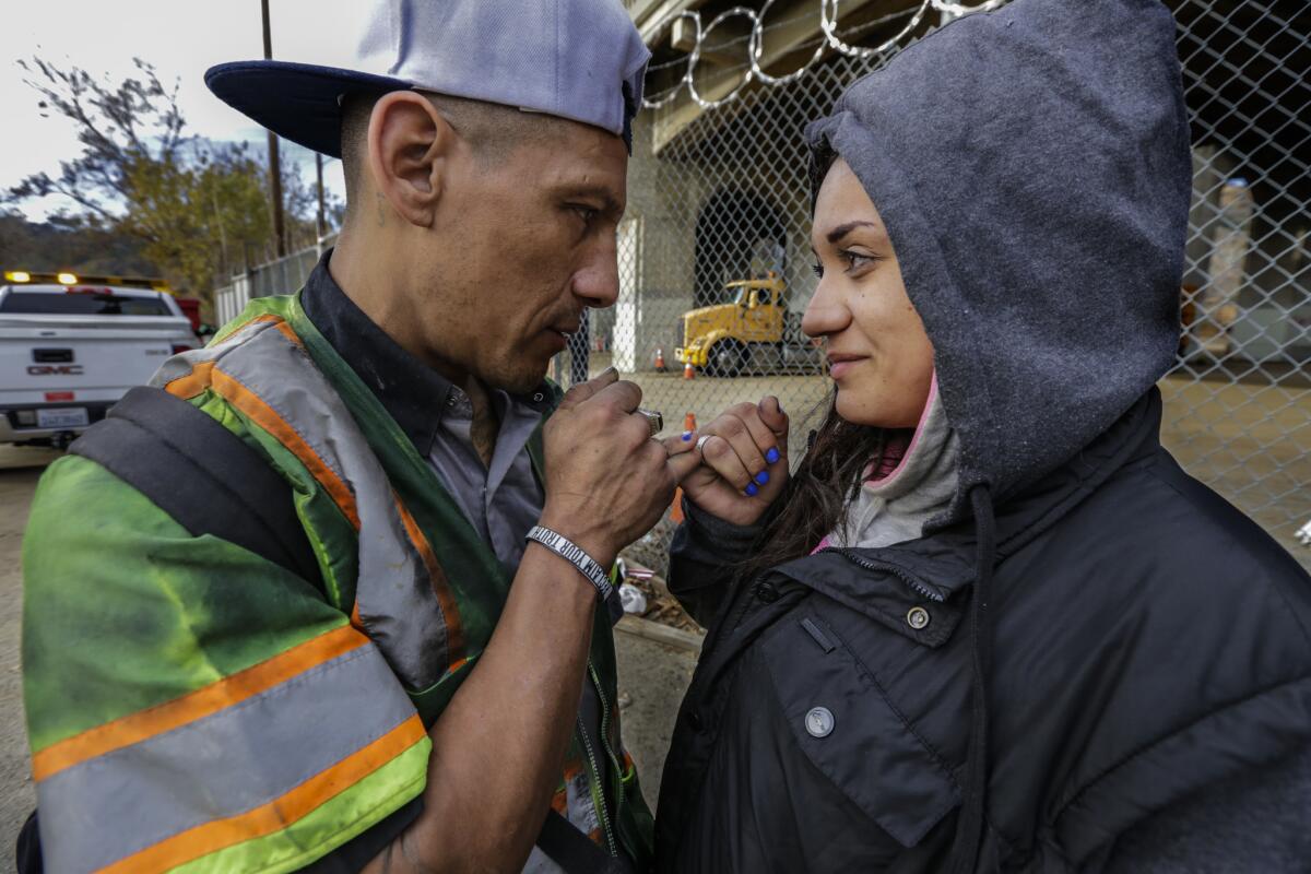 Juan Mendez, 42, and Vanessa Lopez, 24, comfort each other after losing their sleeping place under the Avenue 19 overpass and the 110 Freeway.