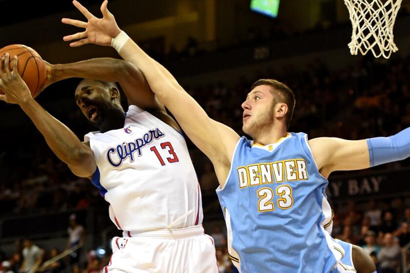Clippers center Ekpe Udoh (13) grabs a rebound from Nuggets center Jusuf Nurkic during a preseason game.