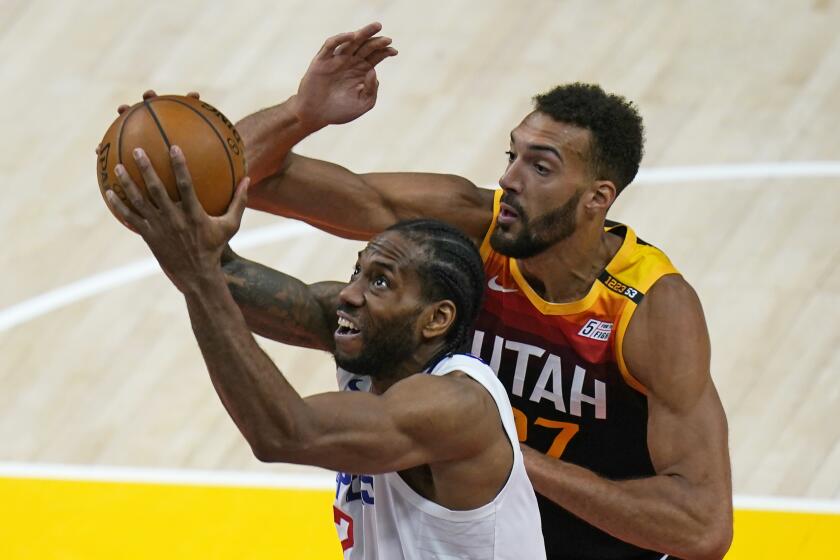 Utah Jazz center Rudy Gobert, rear, defends against Los Angeles Clippers forward Kawhi Leonard.