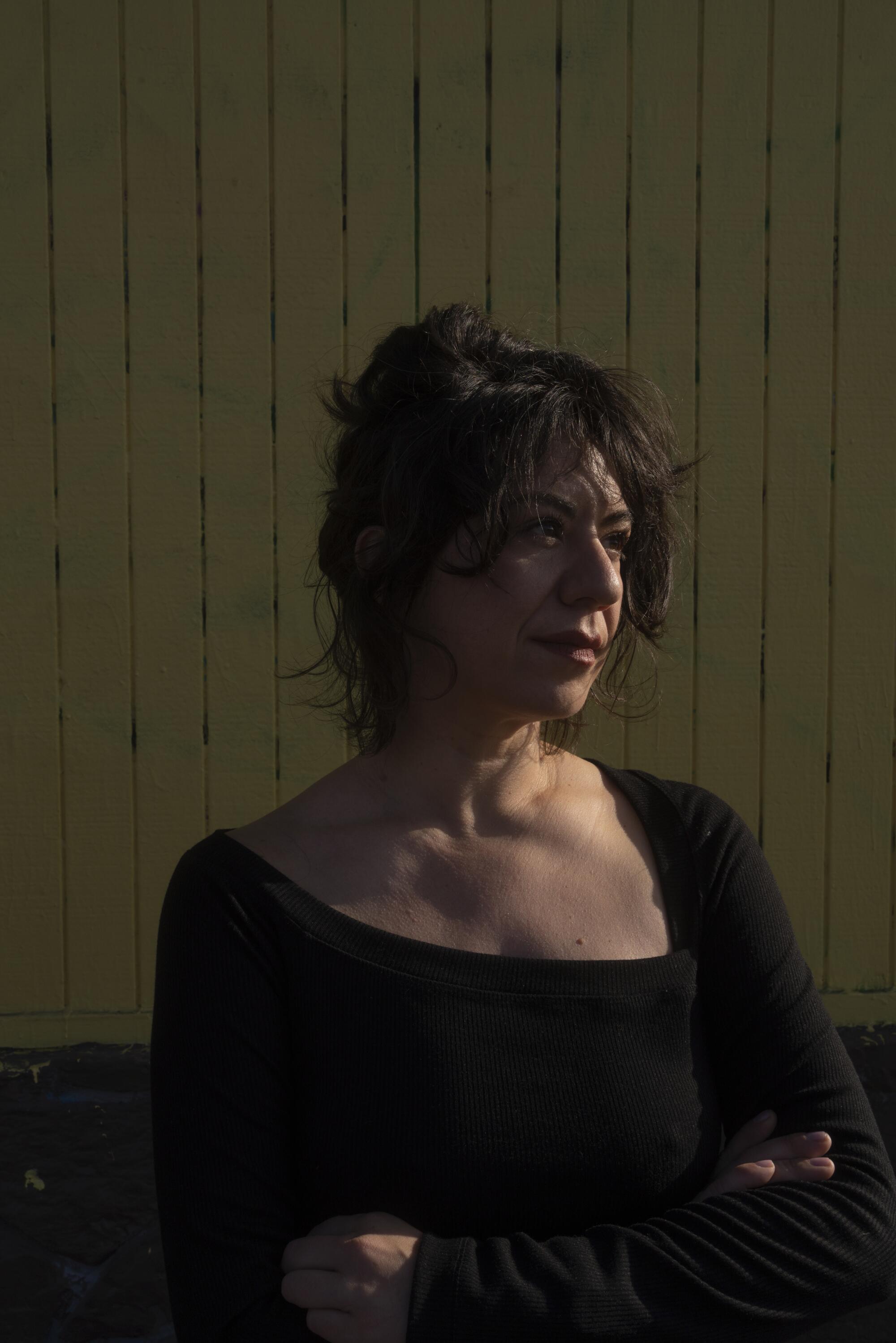 Christina Catherine Martinez, a comedian, writer, and art critic, poses for a portrait with her found Mazda Miata