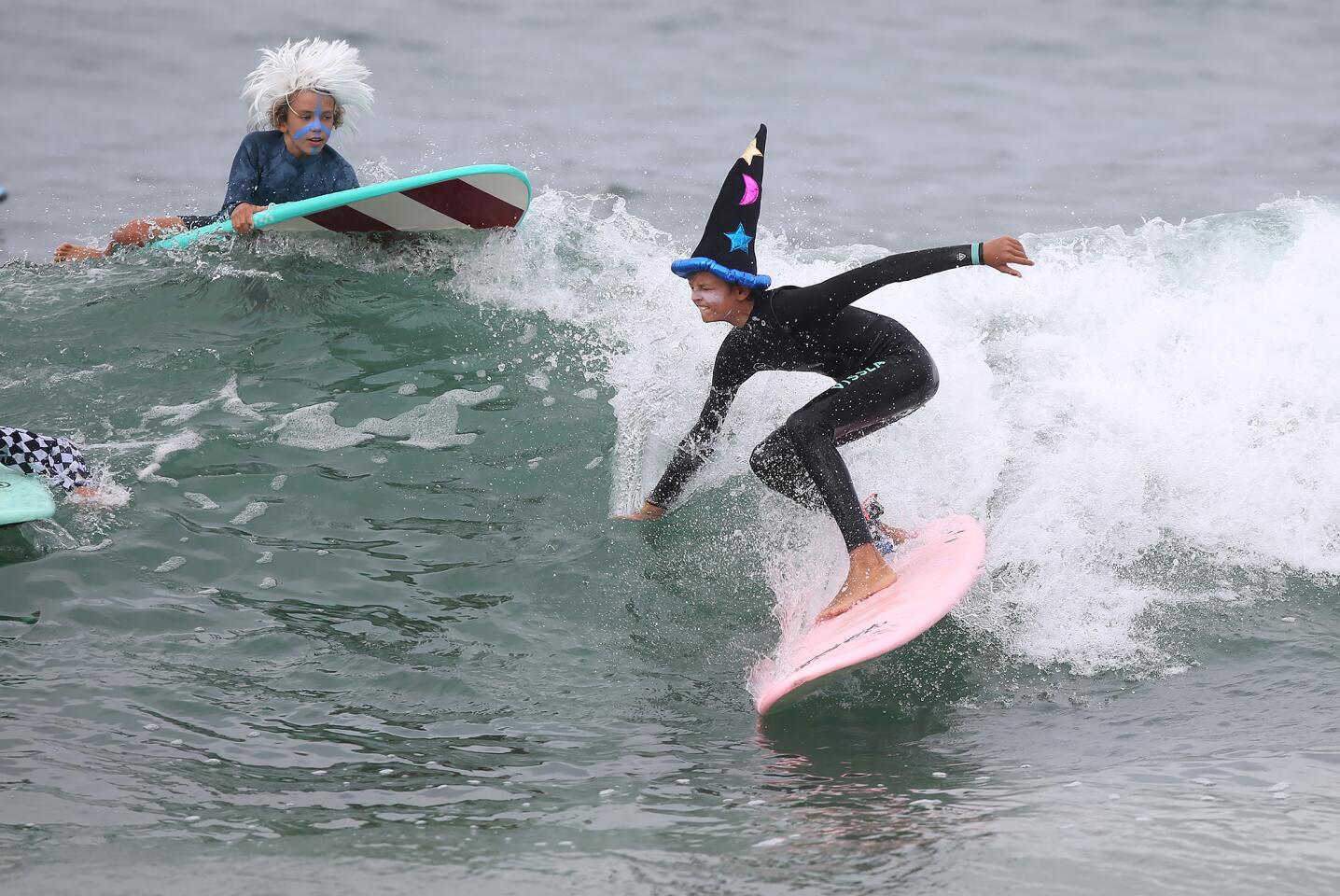 A camp participant dressed as merlin the wizard rides a wave on the final day of the Laguna Beach Surf School summer program for one last day of fun in the sun in Laguna Beach.