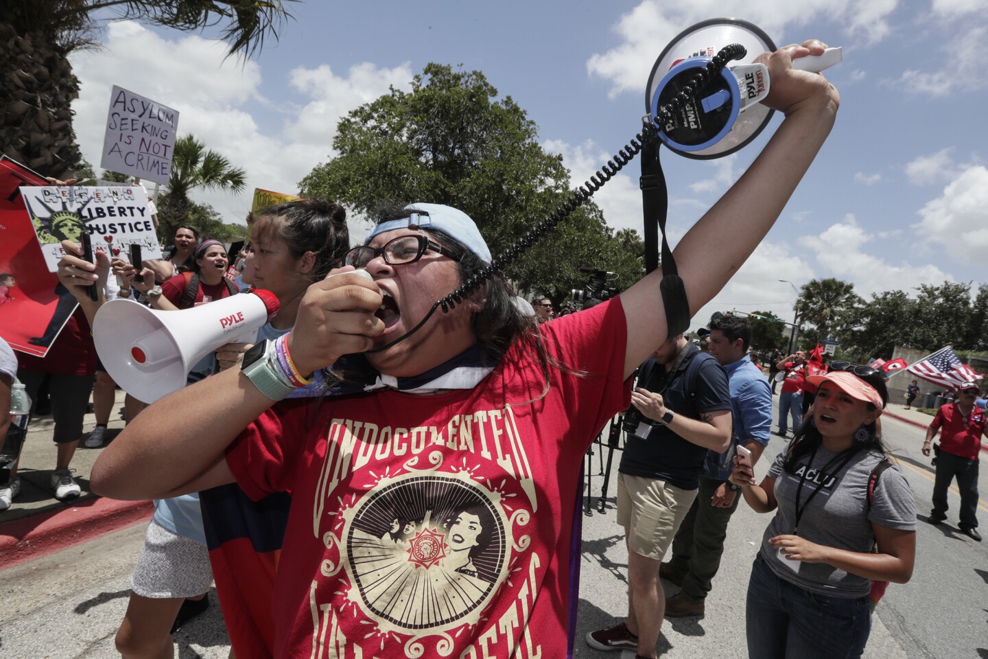 Yuanen Alvarado from Texas State University chants into a loudspeaker during a demonstration against U.S. immigration policies at Linear Park in Brownsville, Tx.