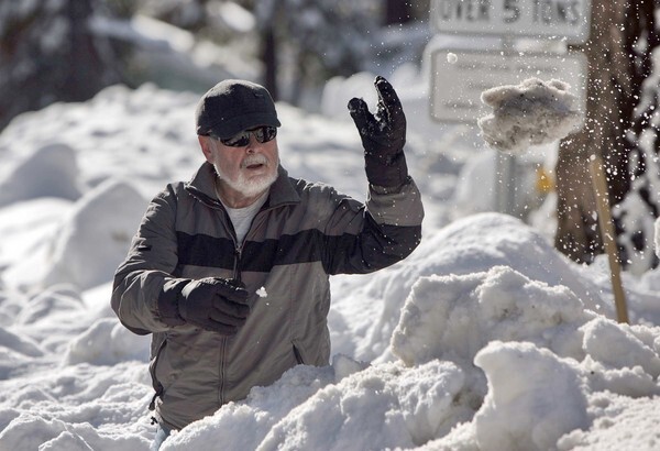 Keith Perkins clears waist-deep snow from his driveway in Wrightwood.