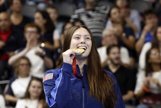 American Gia Pergolini stands on the podium and bites her gold medal after winning the100 meter backstroke S13