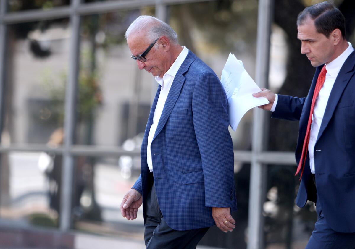 Elias Shokrian, left, owner of Honolulu Manor Senior Apartments, and his attorney, Thomas Sands, leave the L.A. County Superior Courthouse in Glendale, where a judge ordered Shokrian to fix both elevators at the complex. One elevator has been broken for nearly a year.