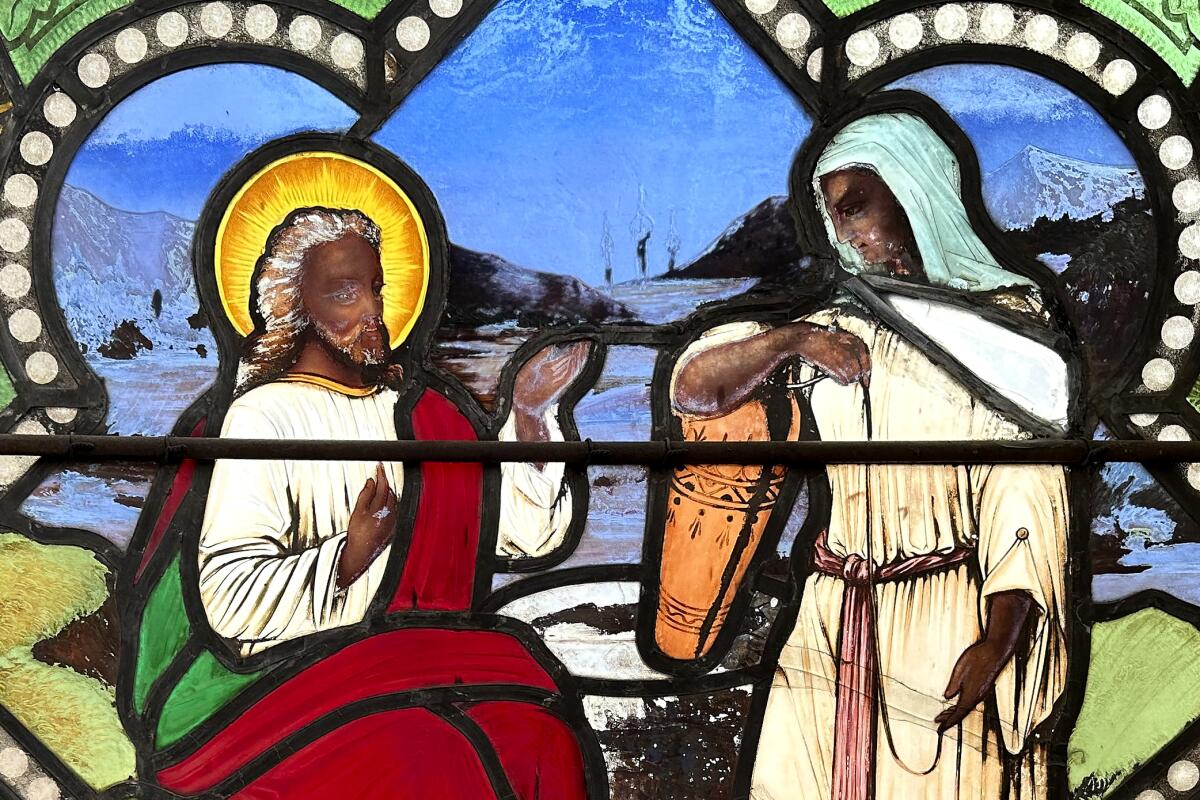 A detail of a nearly 150-year-old stained-glass window depicts Christ speaking to a Samaritan woman