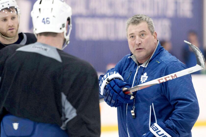 Peter Horachek, right, explains a drill to Roman Polak (46) and Cody Franson at a Maple Leafs practice.