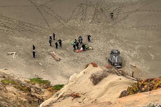 Firefighters at Ocean Beach in San Francisco, where a car plunged off a cliff.