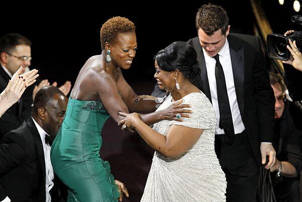 Octavia Spencer, right, is congratulated by "The Help" cast mate Viola Davis on the way to the stage to accept the award for supporting actor.