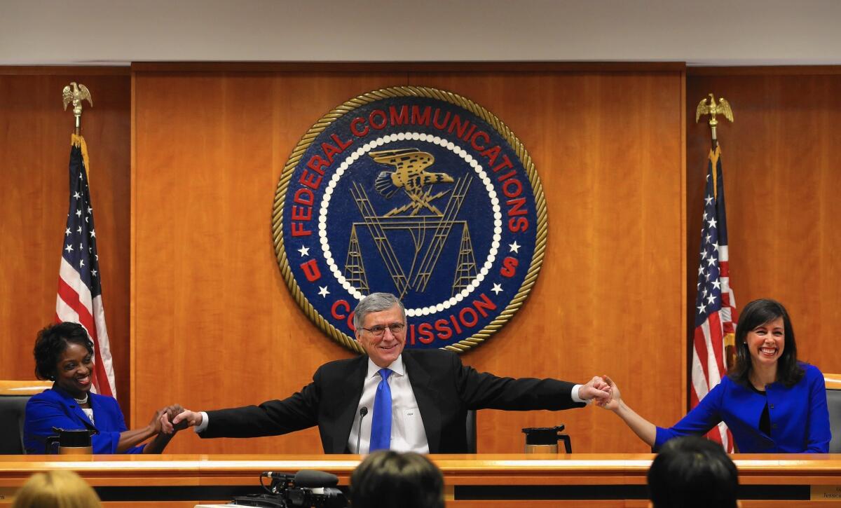 FCC Chairman Tom Wheeler, center, and the FCC’s other two Democratic members — Mignon Clyburn, left, and Jessica Rosenworcel — received a standing ovation from net neutrality backers at the start of the meeting.