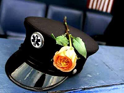 A New York paramedic places his rose and hat on a railing after a memorial service