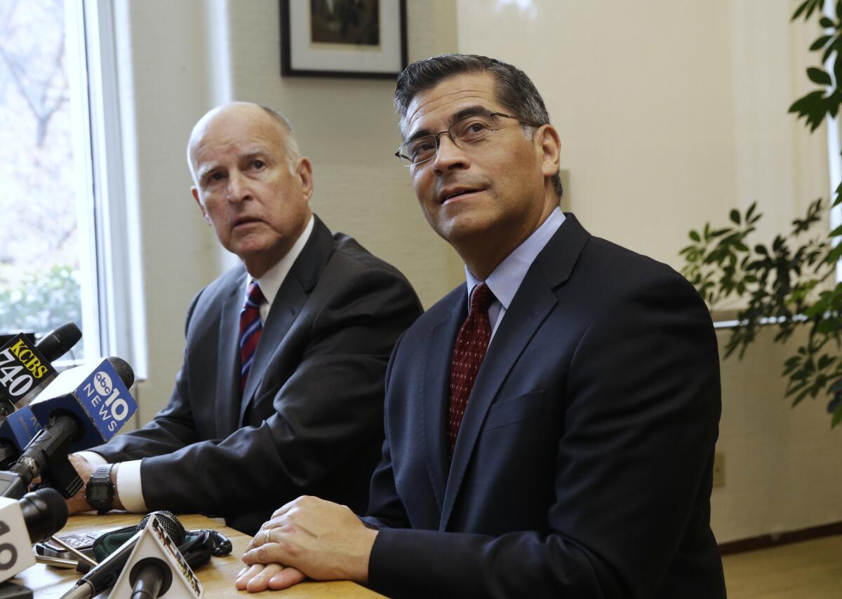 Gov. Jerry Brown, left, and Rep. Xavier Becerra, D-Los Angeles, Brown's nominee for California Attorney General, during a news conference in Sacramento. (Rich Pedroncelli / AP)