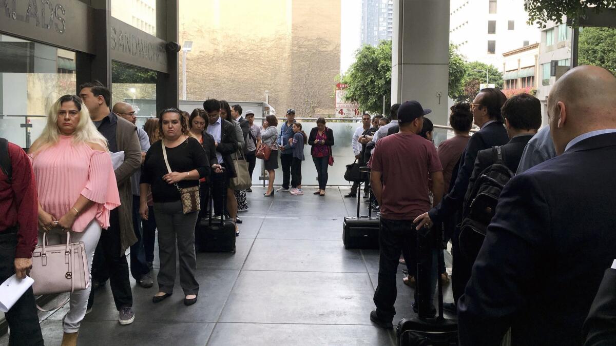 Immigrants awaiting deportation hearings line up last month outside the building that houses the immigration courts in Los Angeles.