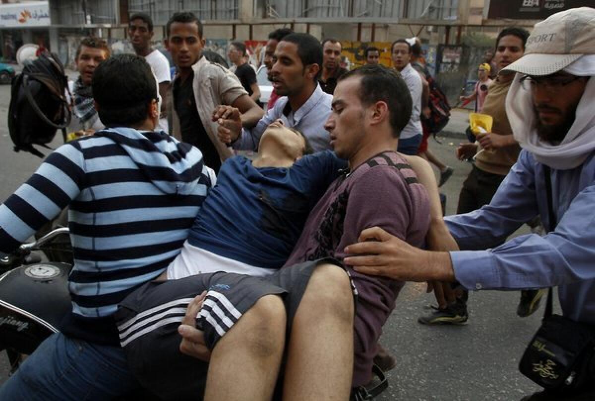 Supporters of ousted Egyptian President Mohamed Morsi carry an injured comrade in Cairo's eastern Nasr City district on Friday after clashes broke out during a demonstration against the military.